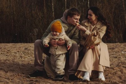 A family enjoys a cozy moment outdoors with their child during autumn. Warm and intimate scene.