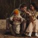 A family enjoys a cozy moment outdoors with their child during autumn. Warm and intimate scene.