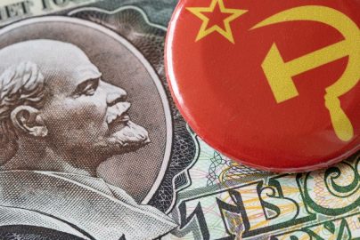 a red button sitting on top of a pile of money